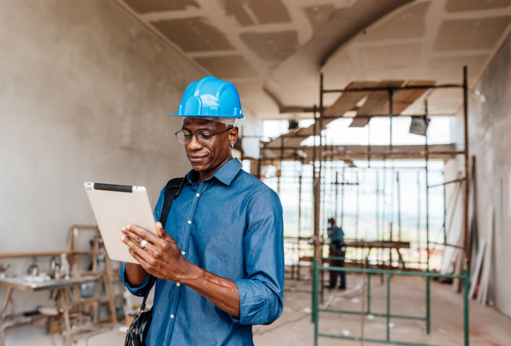 Construction manager reviewing project plans on active job site